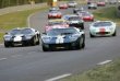 Defilé vozů Ford GT40 různých typů na závodní dráze v Le Mans